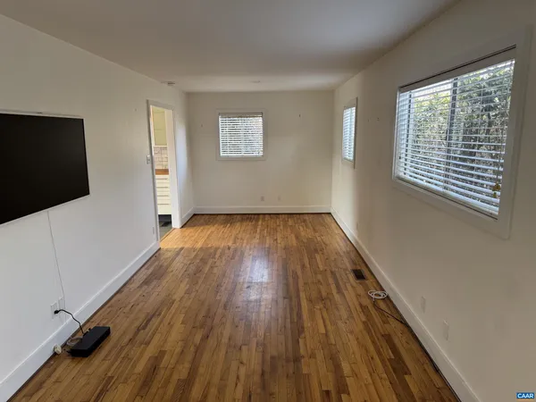 a view of a livingroom with wooden floor and a flat screen tv