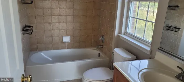 a view of an empty room with wooden floor and windows