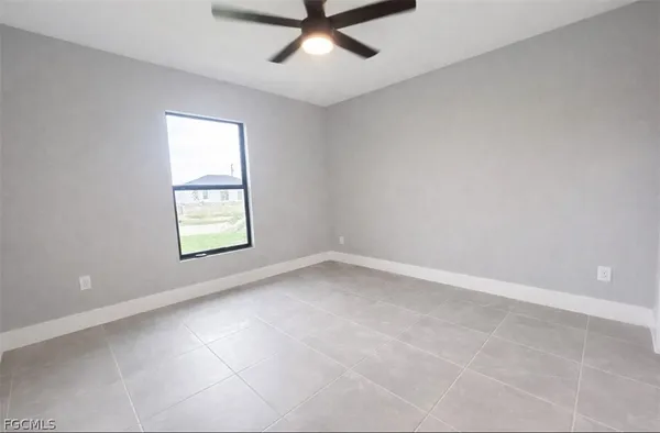 an empty room with a window and a ceiling fan