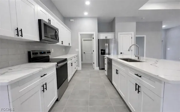 a large white kitchen with stainless steel appliances