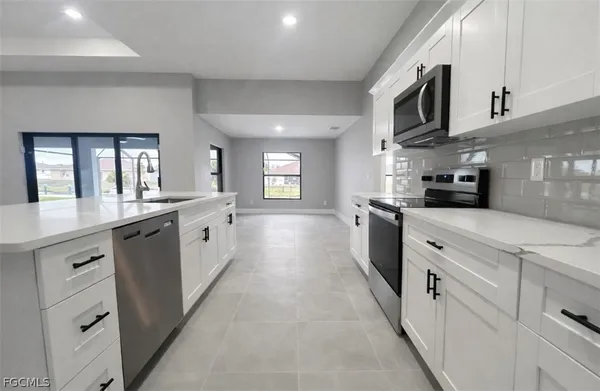a large kitchen with stainless steel appliances lots of counter space sink and cabinets