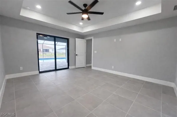 an empty room with windows and ceiling fan