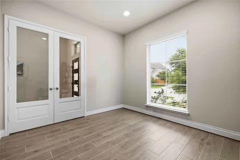 a spacious bedroom with a bed a couch and a large window