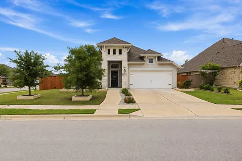 a kitchen with stainless steel appliances granite countertop a stove top oven a sink dishwasher and a refrigerator with wooden floor