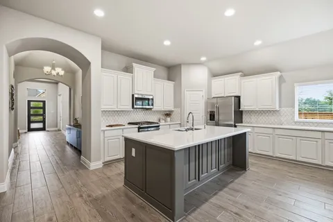 a kitchen with stainless steel appliances granite countertop a sink stove microwave and refrigerator
