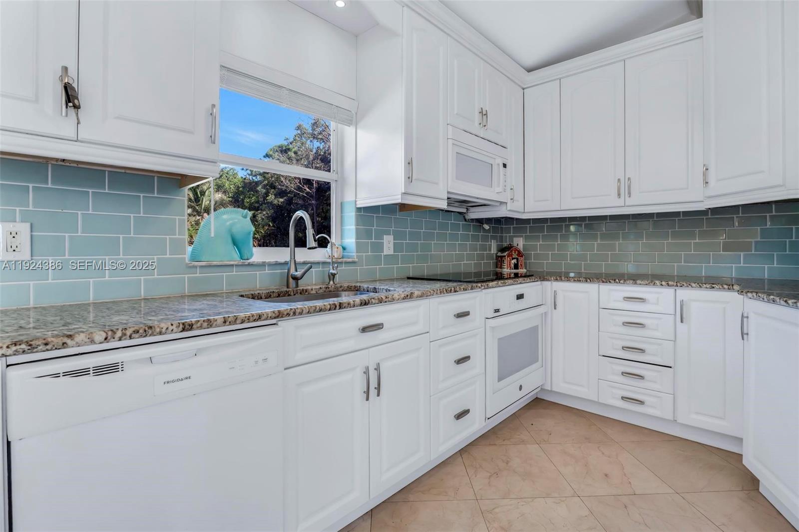 17607 88th Road North Loxahatchee, FL 33470 - Photo 17 of 56 a kitchen with granite countertop white cabinets and white stainless steel appliances
