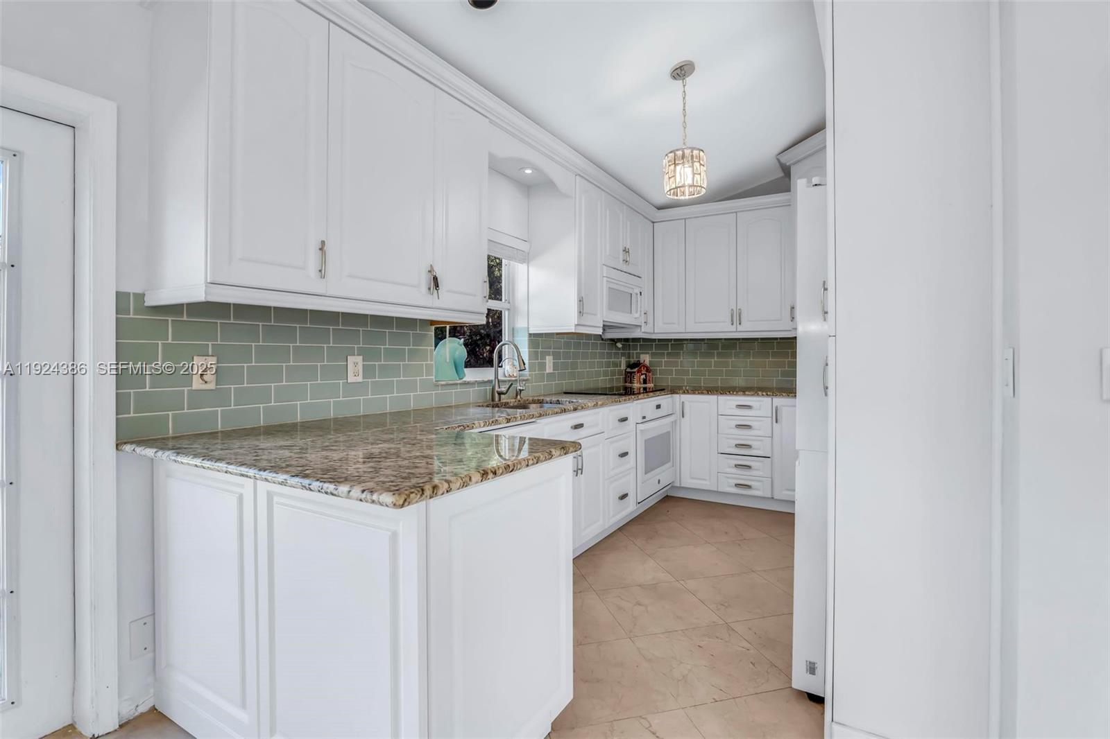 17607 88th Road North Loxahatchee, FL 33470 - Photo 18 of 56 a kitchen with granite countertop a sink stove and cabinets