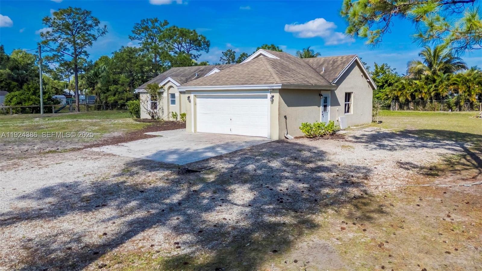 17607 88th Road North Loxahatchee, FL 33470 - Photo 2 of 56 a front view of a house with a yard and garage