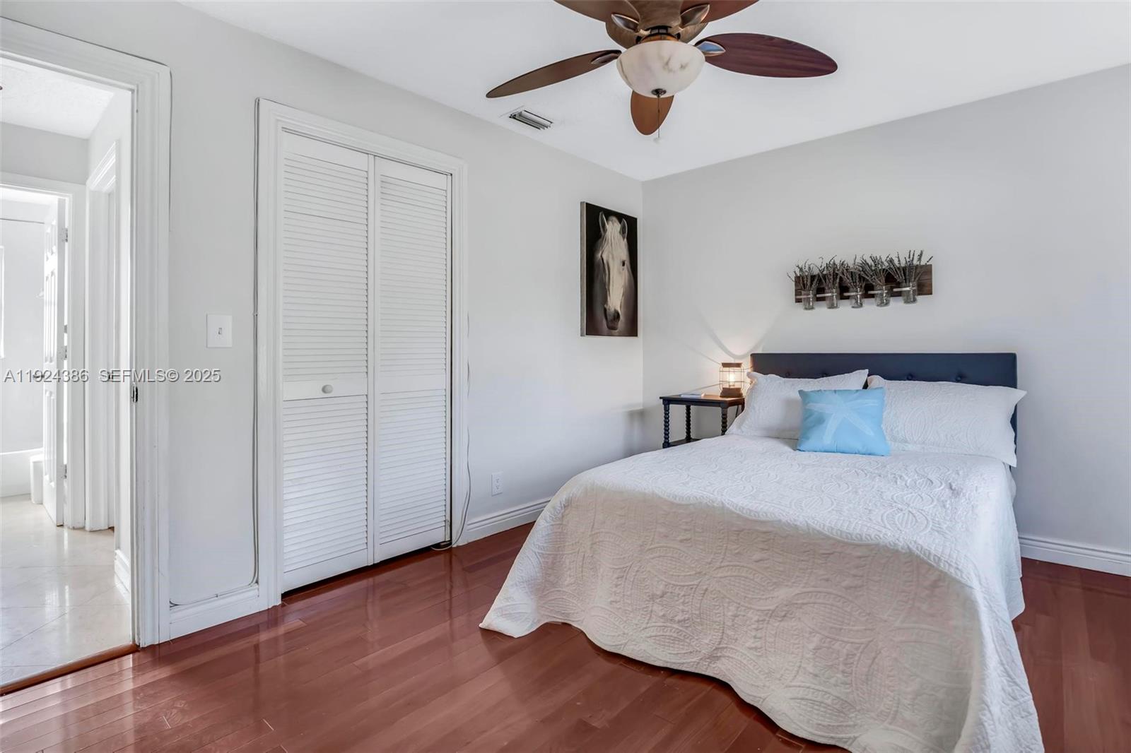 17607 88th Road North Loxahatchee, FL 33470 - Photo 26 of 56 a bedroom with a bed and a chandelier