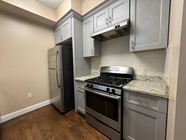 a kitchen with stainless steel appliances granite countertop a stove and a refrigerator