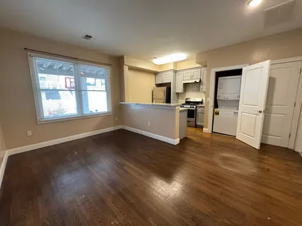 a view of a kitchen with a sink stove cabinets and empty room
