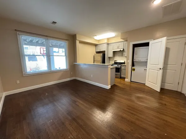 a view of a kitchen with a sink stove cabinets and empty room