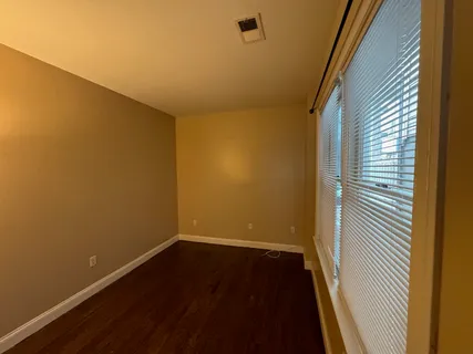 a view of a room with wooden floor and a window