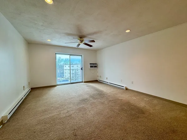 an empty room with windows and ceiling fan view