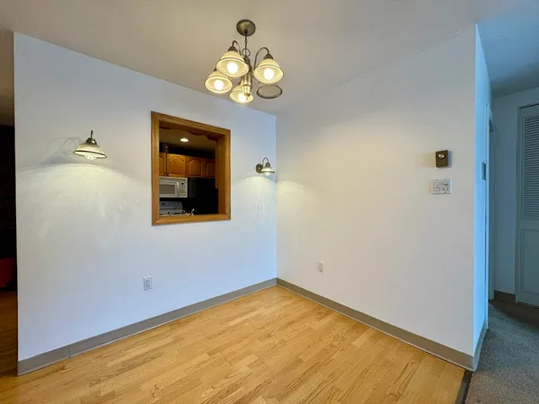 a view of empty room with wooden floor and window