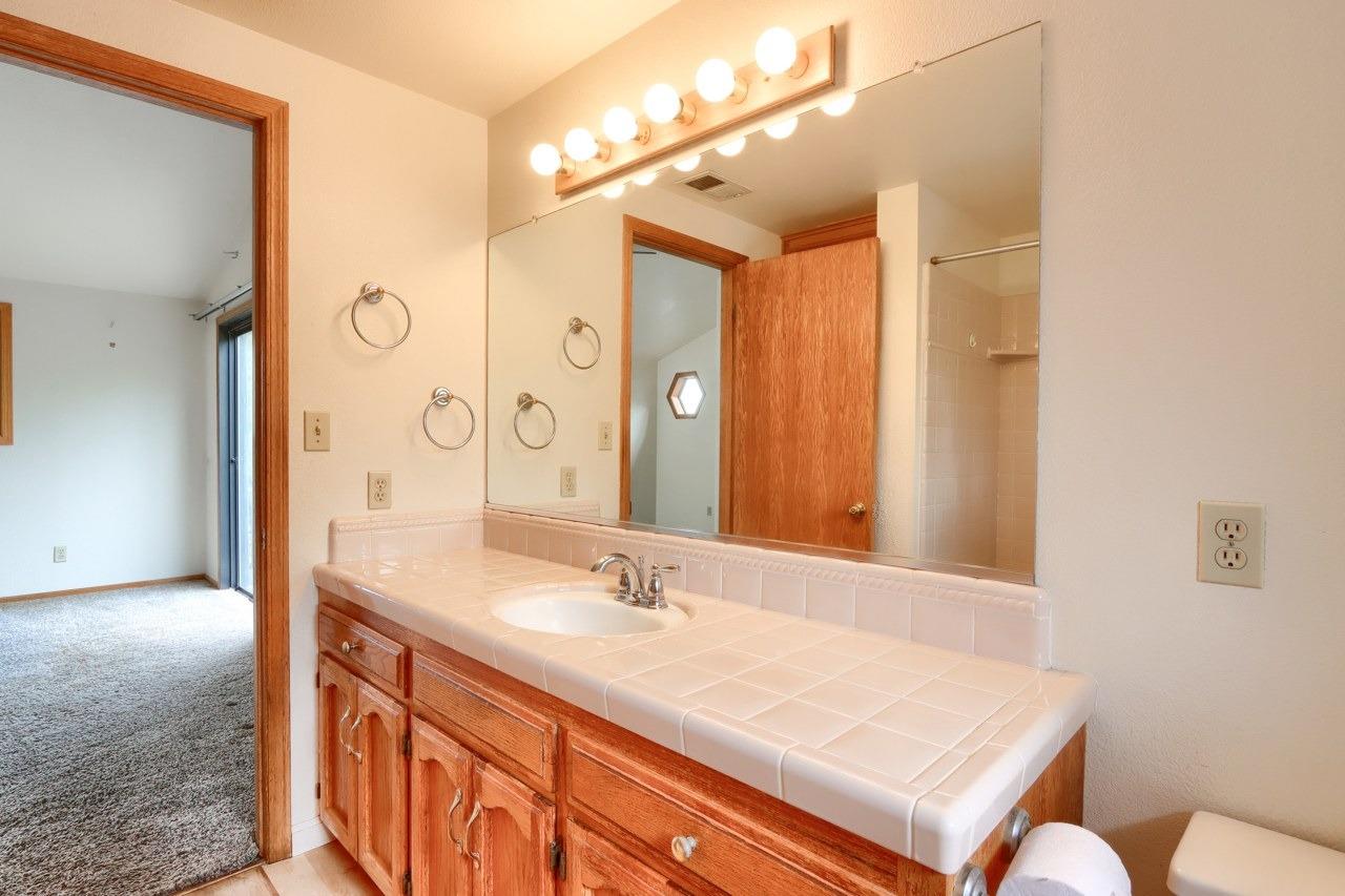 51973 Montgomery Drive Oakhurst, CA 93644 - Photo 37 of 50 a bathroom with a sink double vanity granite tub and a mirror