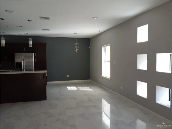 a view of an empty room with window and stairs