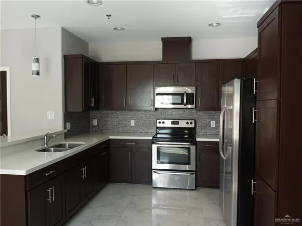 a kitchen with a sink stove and refrigerator