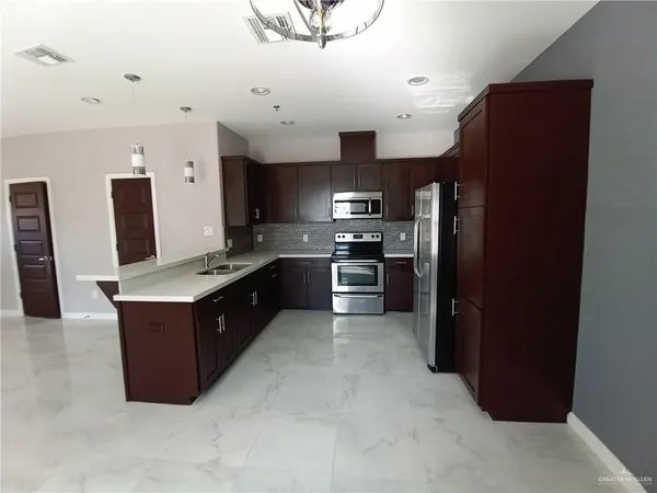 a kitchen with stainless steel appliances granite countertop a refrigerator and a stove