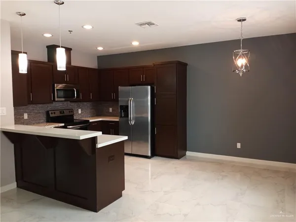 a kitchen with stainless steel appliances granite countertop a stove a refrigerator and a sink