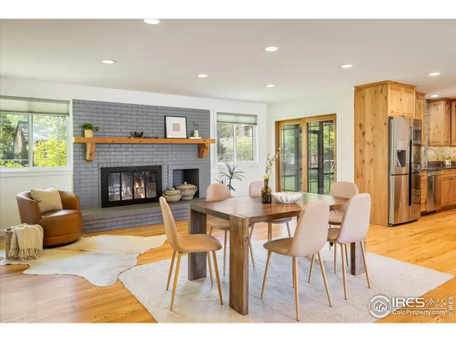 a dining room with furniture a fireplace and wooden floor