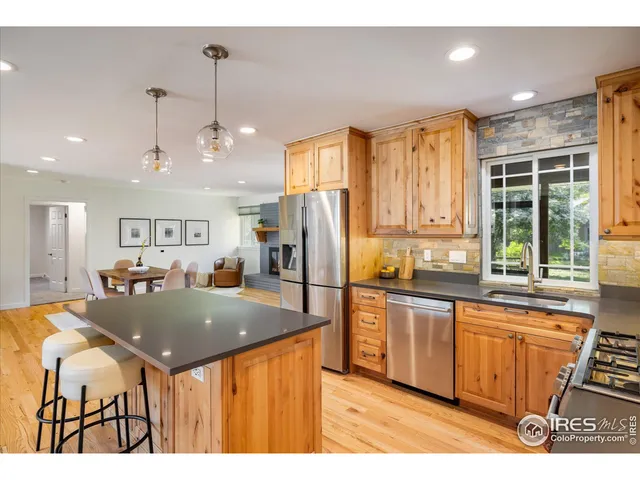 a kitchen with stainless steel appliances granite countertop a sink a stove and a refrigerator