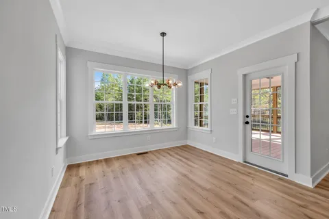 a view of an empty room with glass door and wooden floor
