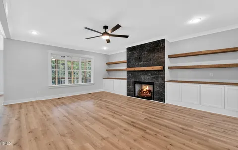 a view of an empty room with a window and fireplace