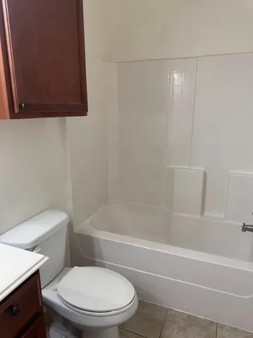 a white toilet and tub sitting next to a bathroom sink