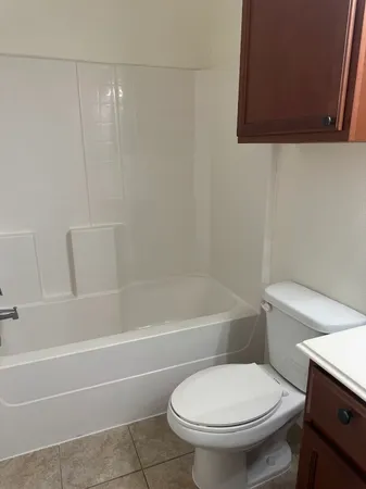 a white toilet and tub sitting next to a bathroom sink