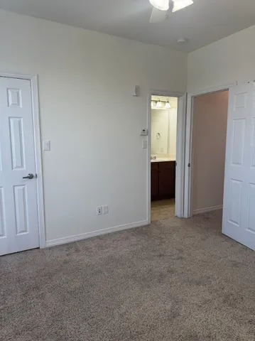 a view of an empty room with closet and a window