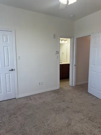 a view of an empty room with closet and a window
