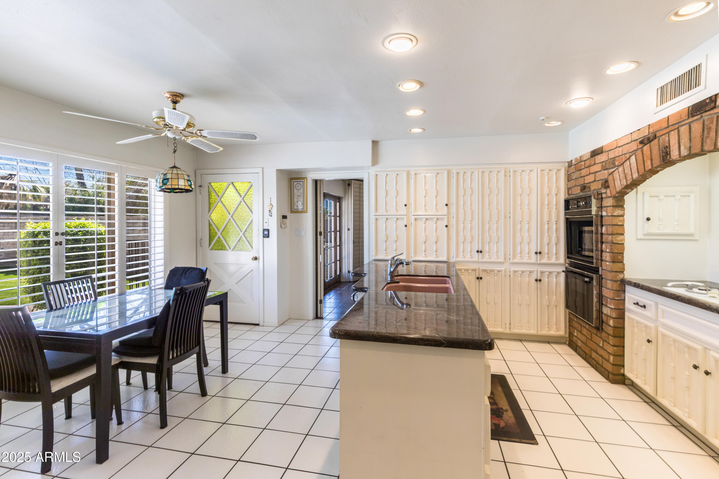 7125 North 2nd Place Phoenix, AZ 85020 - Photo 9 of 30 a kitchen with granite countertop a stove a sink a dining table and chairs