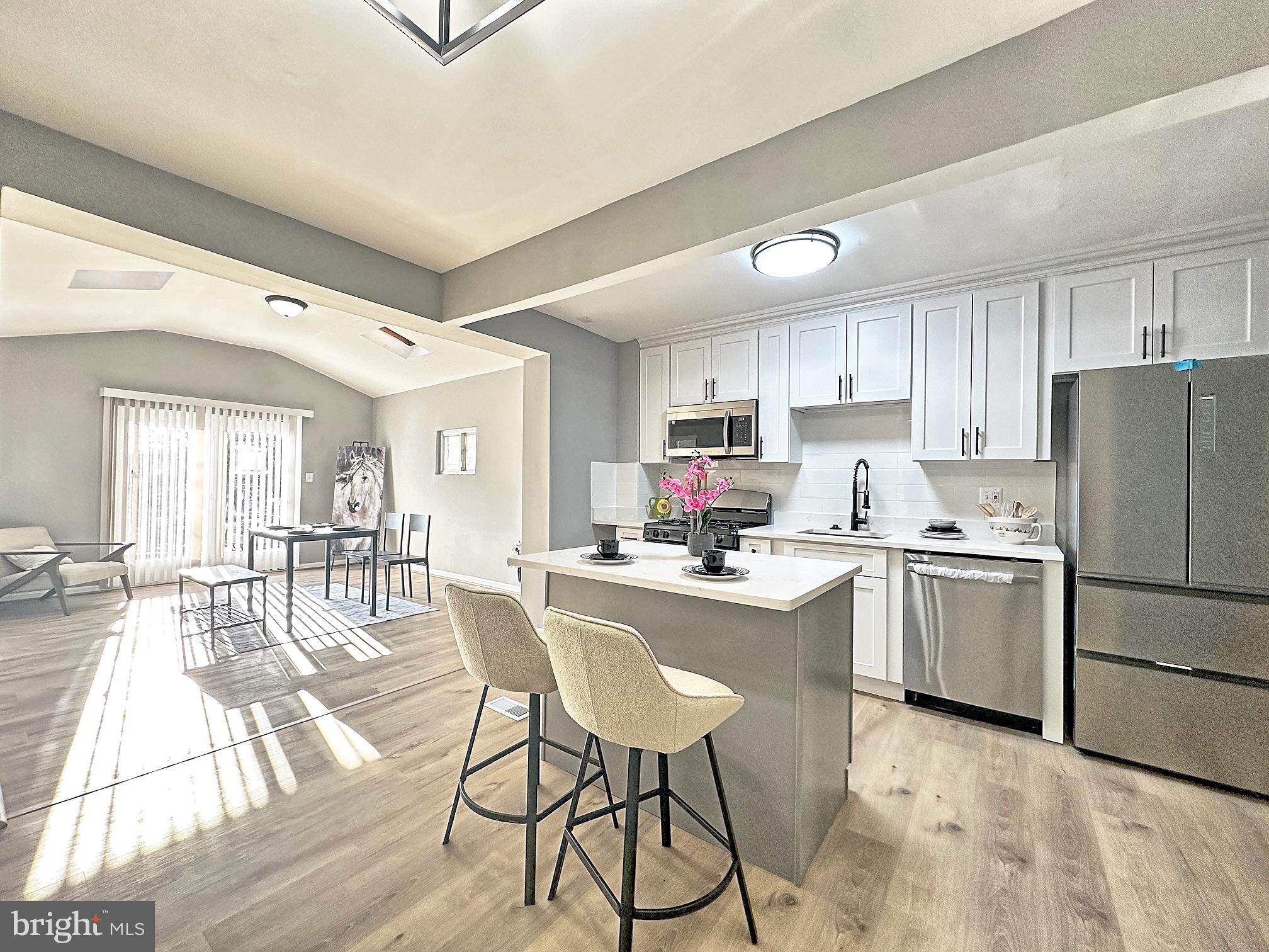 116 Hillvale Road Baltimore, MD 21229 - Photo 8 of 26 a kitchen with refrigerator cabinets dining table and chairs