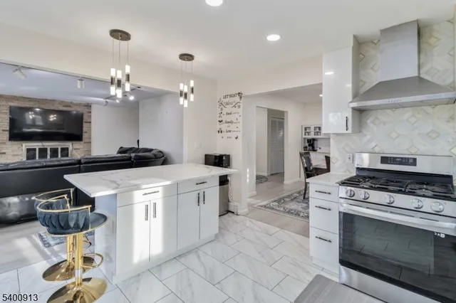 a kitchen with stainless steel appliances granite countertop a stove a sink and a microwave