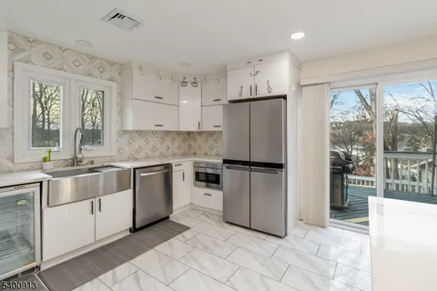 a kitchen with granite countertop a refrigerator and a sink