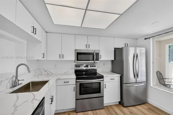 a kitchen with stainless steel appliances a refrigerator sink and microwave
