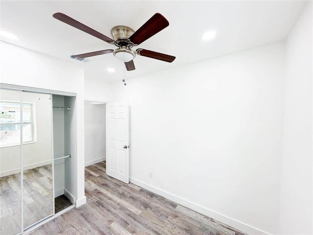 778 Northwest 80th Street Miami, FL 33150 - Photo 13 of 35 an empty room with wooden floor fan and windows