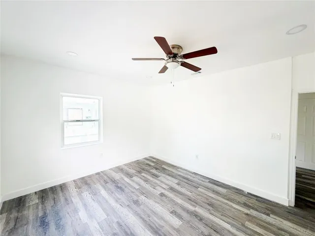 a view of a big room with wooden floor closet and windows