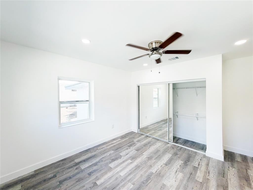 778 Northwest 80th Street Miami, FL 33150 - Photo 16 of 35 a view of empty room with wooden floor and ceiling fan