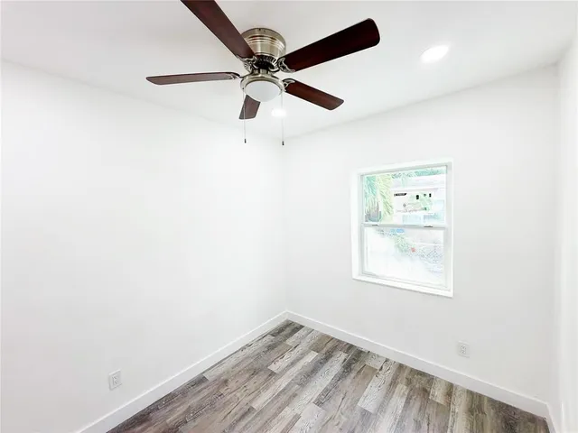an empty room with a window and a fan