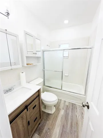 a bathroom with a sink a toilet a mirror and shower
