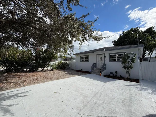 a view of a house with a tree in front of it
