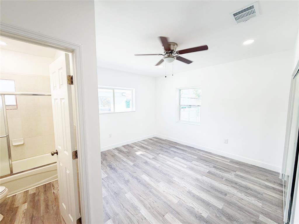 778 Northwest 80th Street Miami, FL 33150 - Photo 21 of 35 a view of empty room with wooden floor and fan