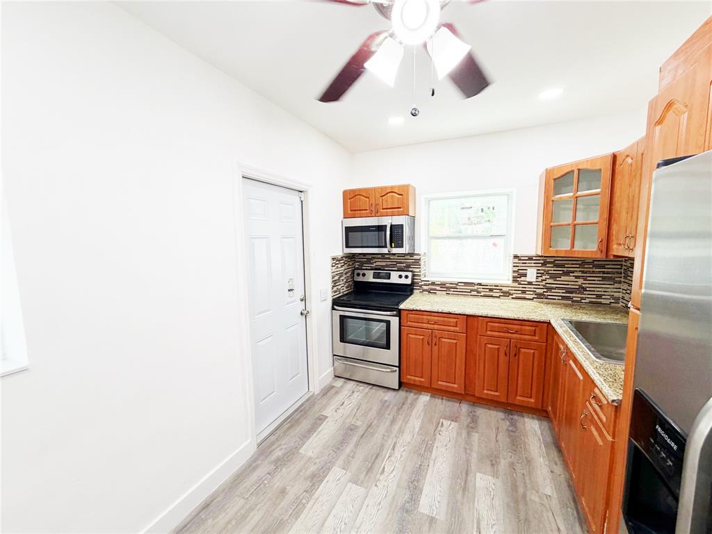 778 Northwest 80th Street Miami, FL 33150 - Photo 5 of 35 a kitchen with stainless steel appliances granite countertop a stove and a refrigerator
