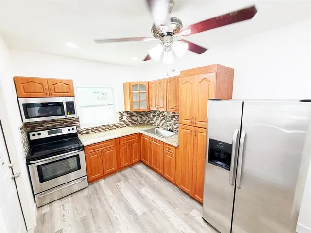 a kitchen with stainless steel appliances a stove a microwave and a refrigerator