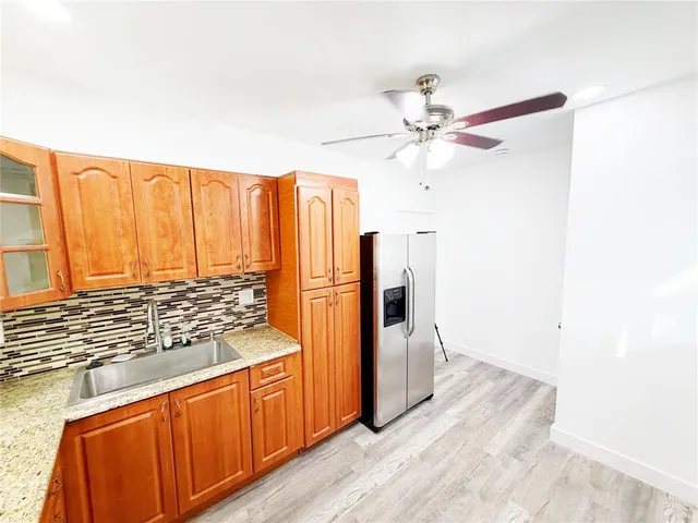 a kitchen with stainless steel appliances granite countertop a refrigerator a stove and a sink