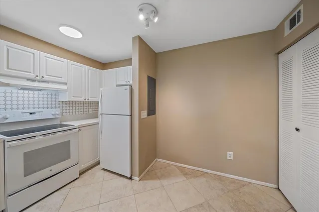 a kitchen with a stove refrigerator and cabinets