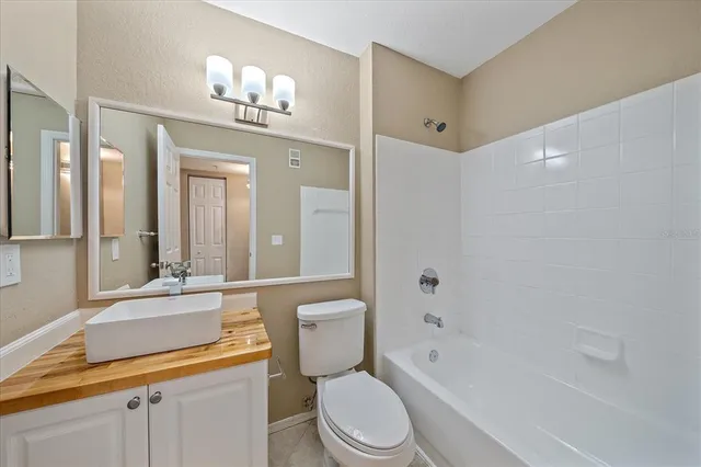 a bathroom with a toilet a sink a tub and mirror