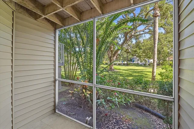 a view of a room with a large window and wooden floor